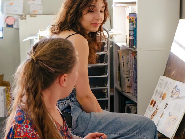 This is an image of a teen discussing color and technique with Miss Chelsea.