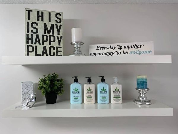 Decorative shelves with inspirational signs, candles, a plant, and skincare products.