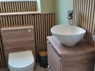 Modern bathroom with wooden accents and a white vessel sink.