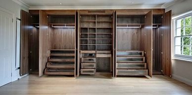 Spacious, modern wooden closet with multiple compartments and drawers.
