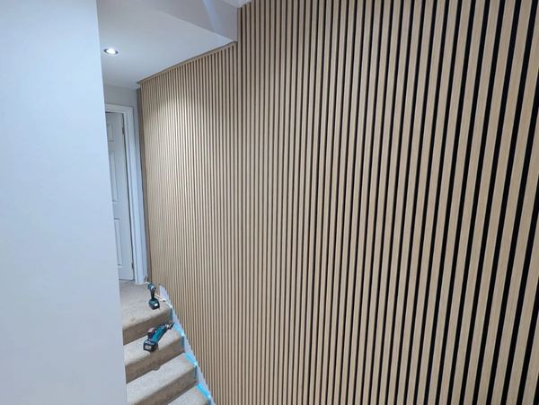 Modern staircase wall with vertical wooden slats.
