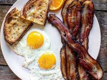 Eggs, bacon and toast withan orange slice