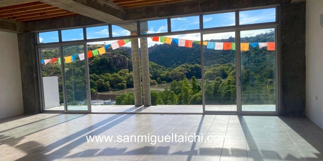 Spacious room with large glass windows overlooking a scenic mountain view.