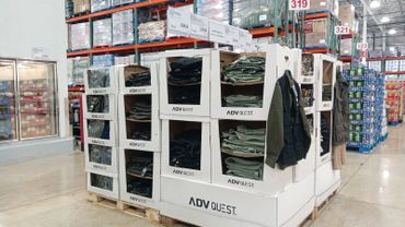 Display of folded pants for sale in a warehouse store aisle.