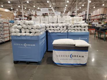 Large display of Serene Dream pillows and pillow protectors in a warehouse store.