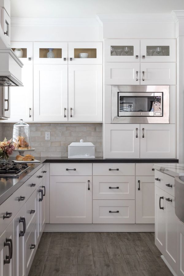 White cabinets with dark quartz countertops and stainless appliances 