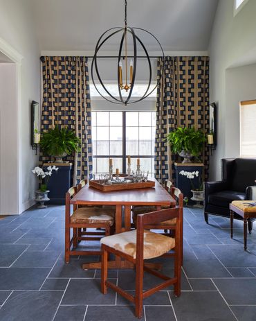 Dining room with large round light fixture with linen patterned drapery 