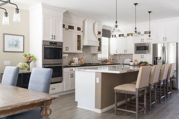 White kitchen with island seating next to dining table 