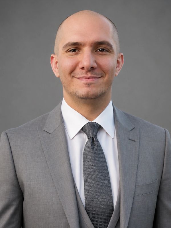 Smiling bald man in gray suit and tie.