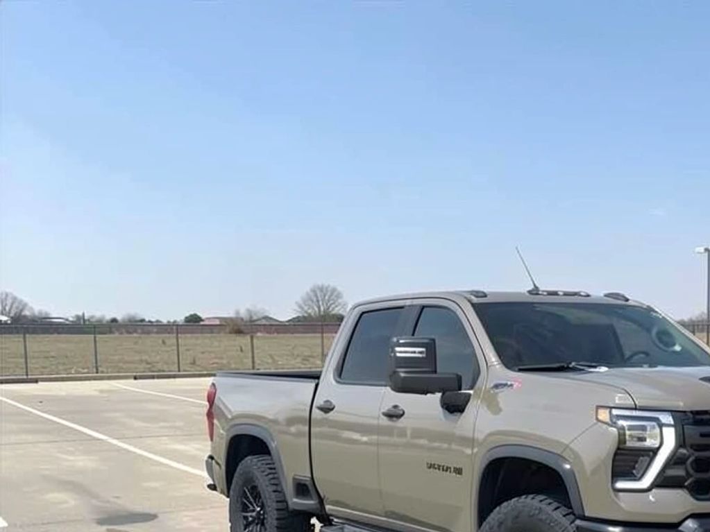 A gray Chevrolet Silverado pickup truck parked in an empty lot under clear skies.