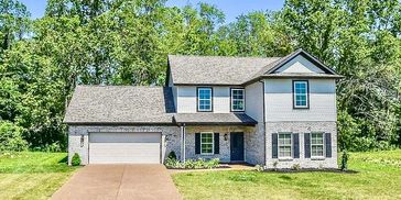 Modern two-story house with a brick facade and attached garage.