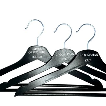 Custom black groomsman coat hangers with names for bridal party.