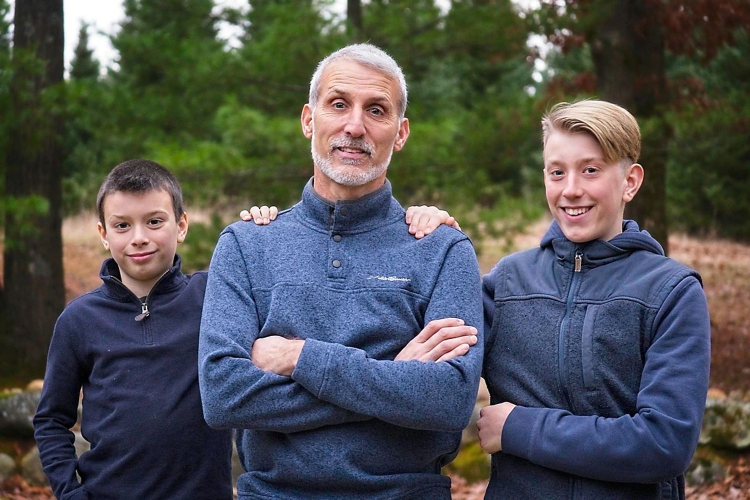 Father and two sons in the woods.