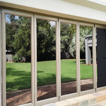 Glass doors reflecting a green garden outside.