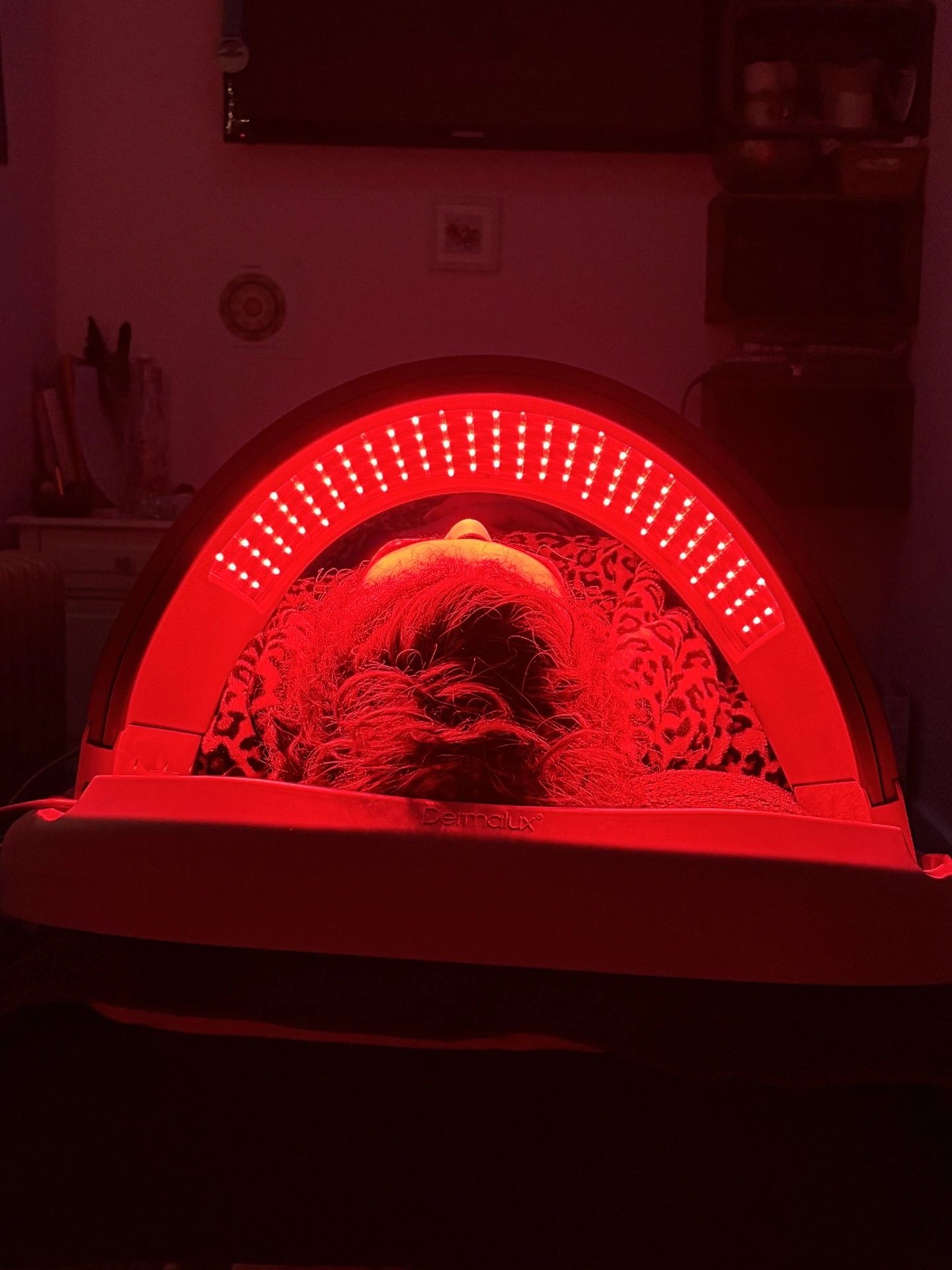 Person undergoing red light therapy on their face with a Dermalux device.