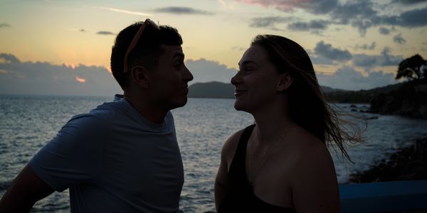 Couple sharing a quiet moment by the sea at sunset.