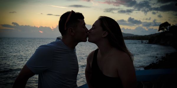 Couple kissing at sunset by the sea.