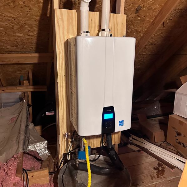 Modern tankless water heater installed in an attic space.