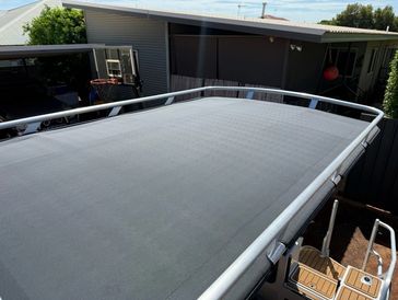 Boat canopy top, gray fabric, metal railing.