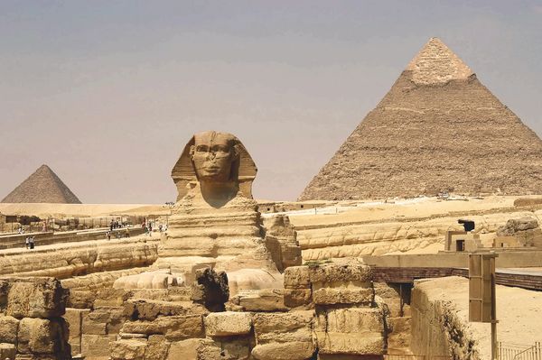 The Great Sphinx and pyramids of Giza under a clear sky.
