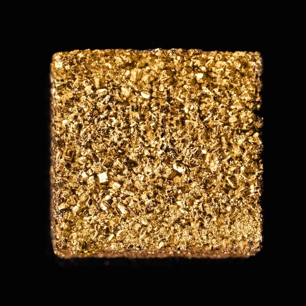 The photo shows a 24 carat gold-plated sugar cube of the brand GOLD SUGAR. Markro shot.