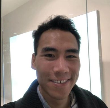 Smiling man taking a selfie indoors.