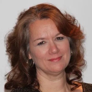 Woman with shoulder-length brown hair smiling.