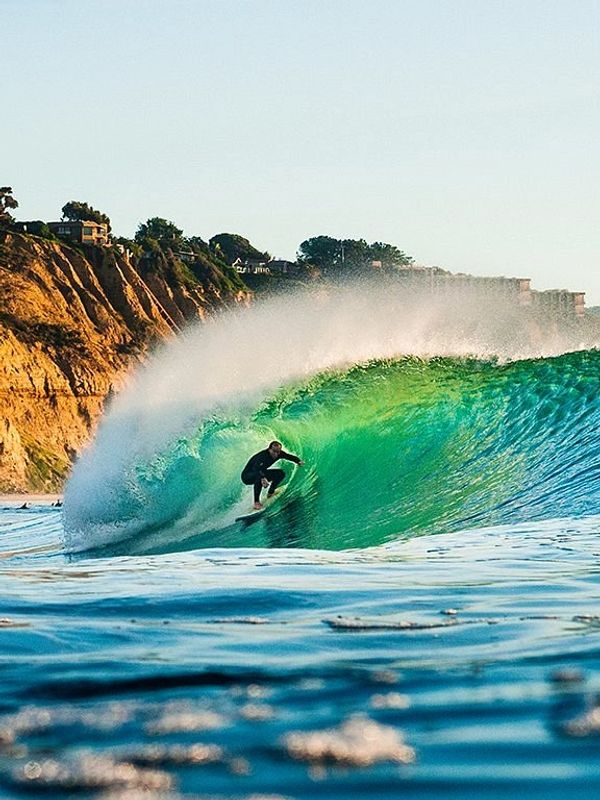 Man surfing in the curl of the waves at Torrey Pines State Beach, San Diego, California 