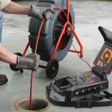 Technician uses a sewer inspection camera to check a drain pipe.