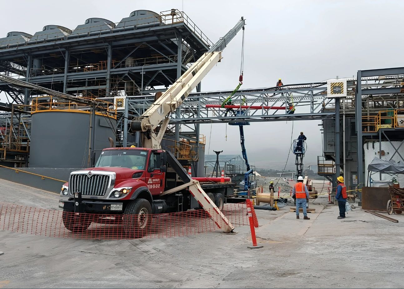 Trabajadores y grúa en construcción industrial.