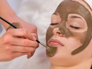 Applying a facial mask with a brush.