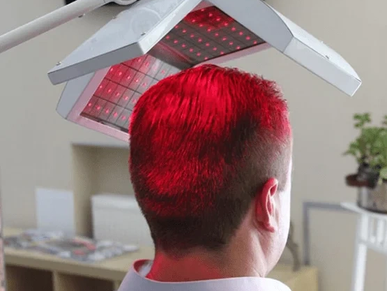 Man undergoing red light therapy on his scalp.