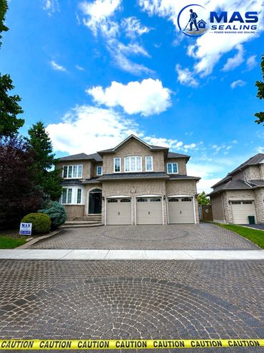 Large suburban house with a clean driveway and caution tape in front.