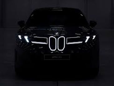 Faróis iluminados de um carro BMW à noite.