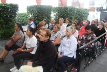 Personas sentadas en una reunión al aire libre.