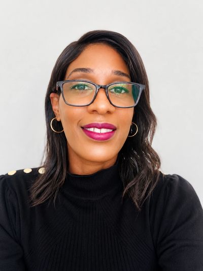 Woman with glasses smiling.