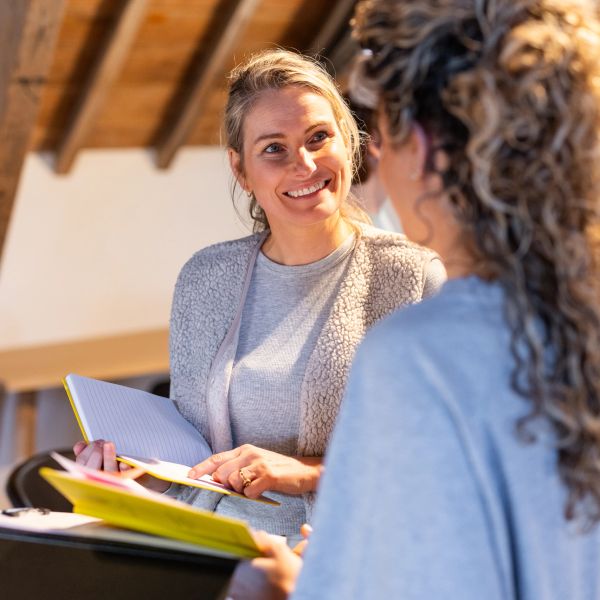 Twee vrouwen praten en houden boeken vast.