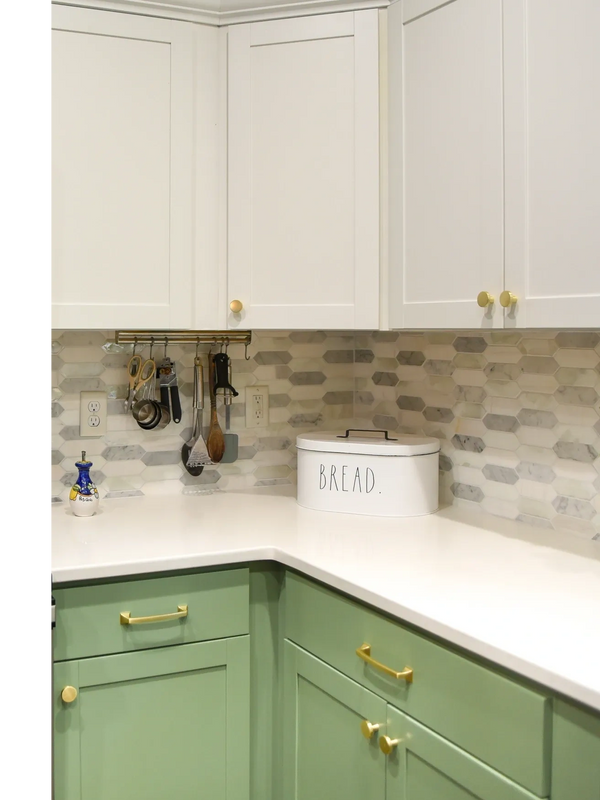 Modern two-toned painted kitchen cabinets with decorative crown molding and brushed gold hardware