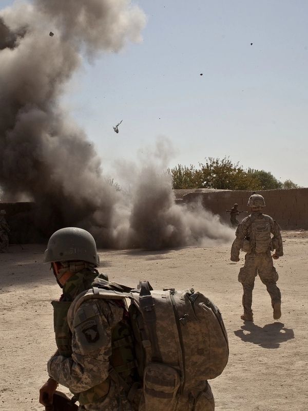 Explosion near soldiers in a desert area.