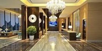 Luxurious hotel lobby with chandeliers and polished marble flooring.