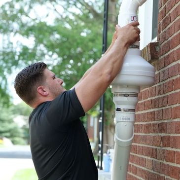 Expert technician installing a state-of-the-art radon mitigation system in a Winston-Salem, NC home,