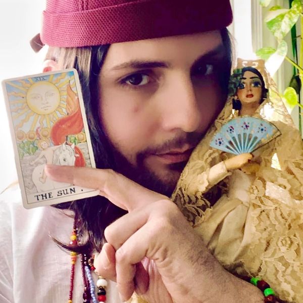 Tarot reader, James Mori holding the Sun card