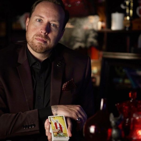 Tarot reader, Matt Bruce with Magician tarot card 