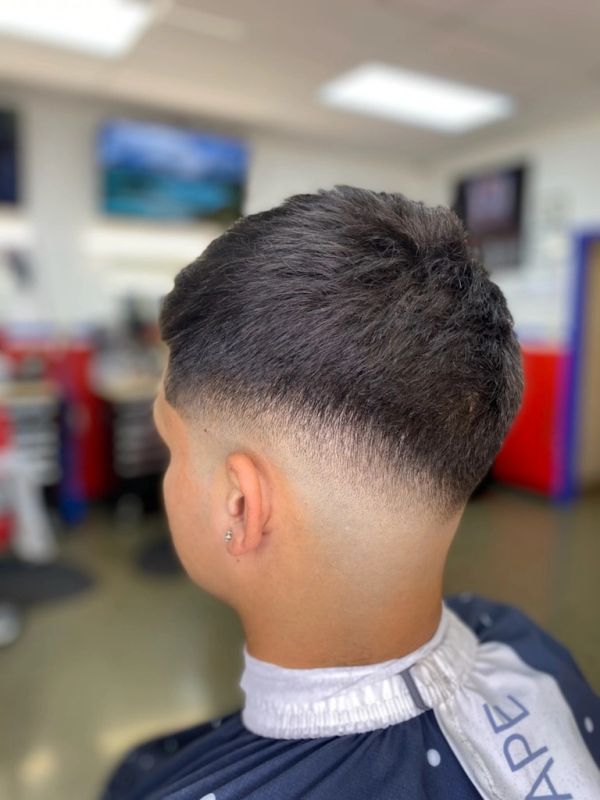 Fresh fade haircut with a clean taper on the back of the head.