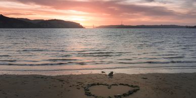 Benicia Beach at sunset. View of the water with the Carquinez Bridge in the distance.