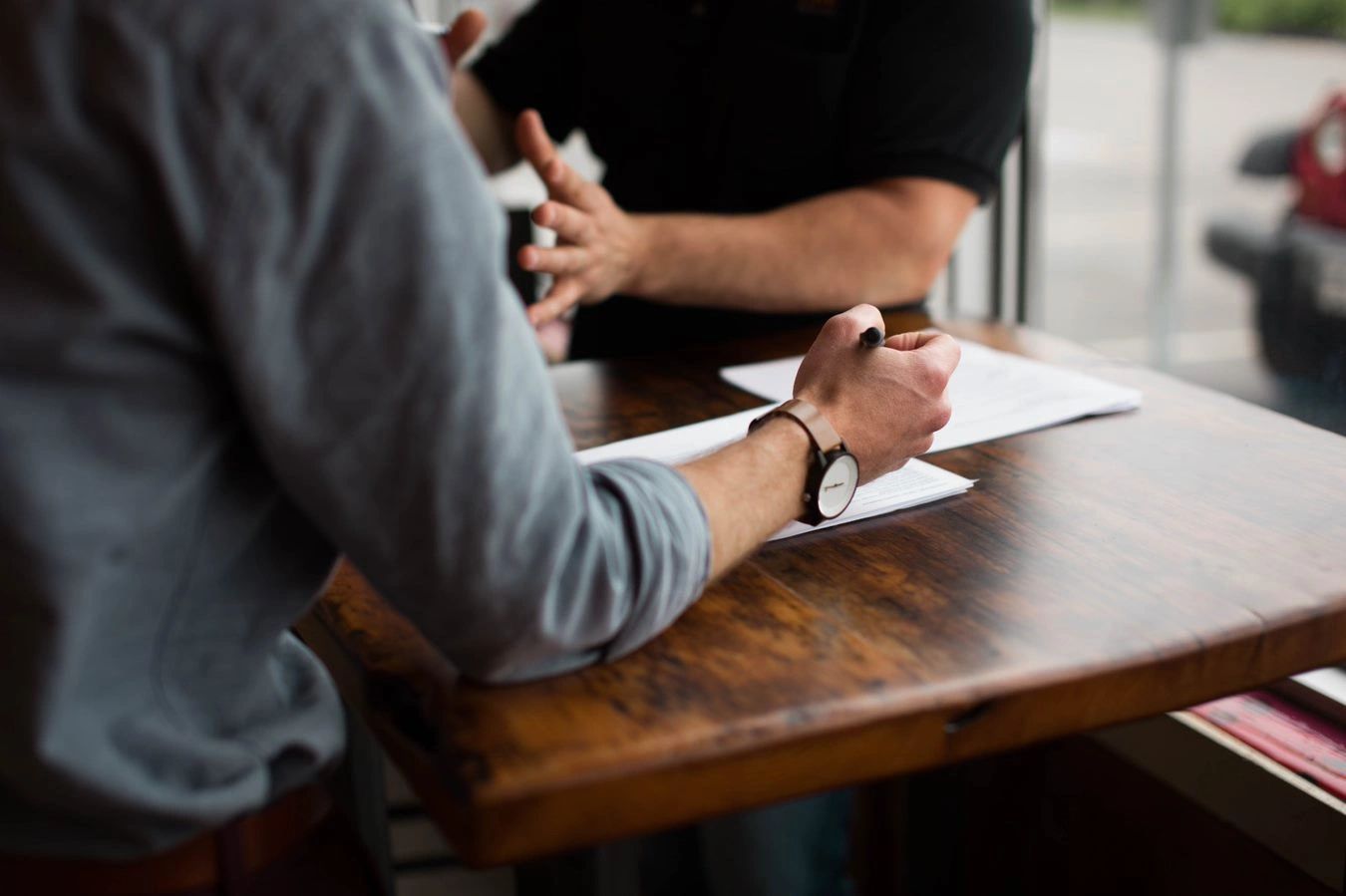 Two men sitting at a table having a discussion