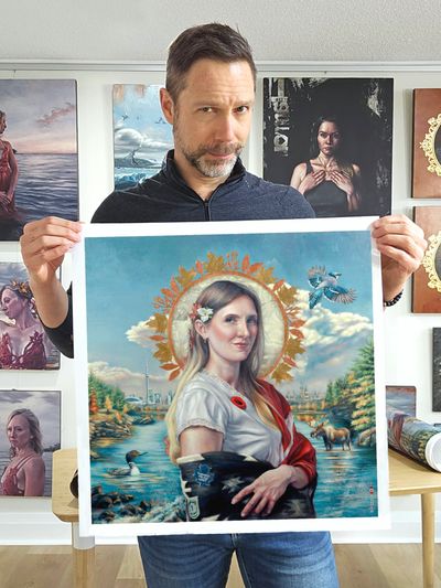 Man holding a detailed painting of a woman with a glowing halo and nature background.