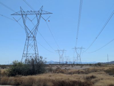 High-voltage power lines crossing a dry, arid landscape.