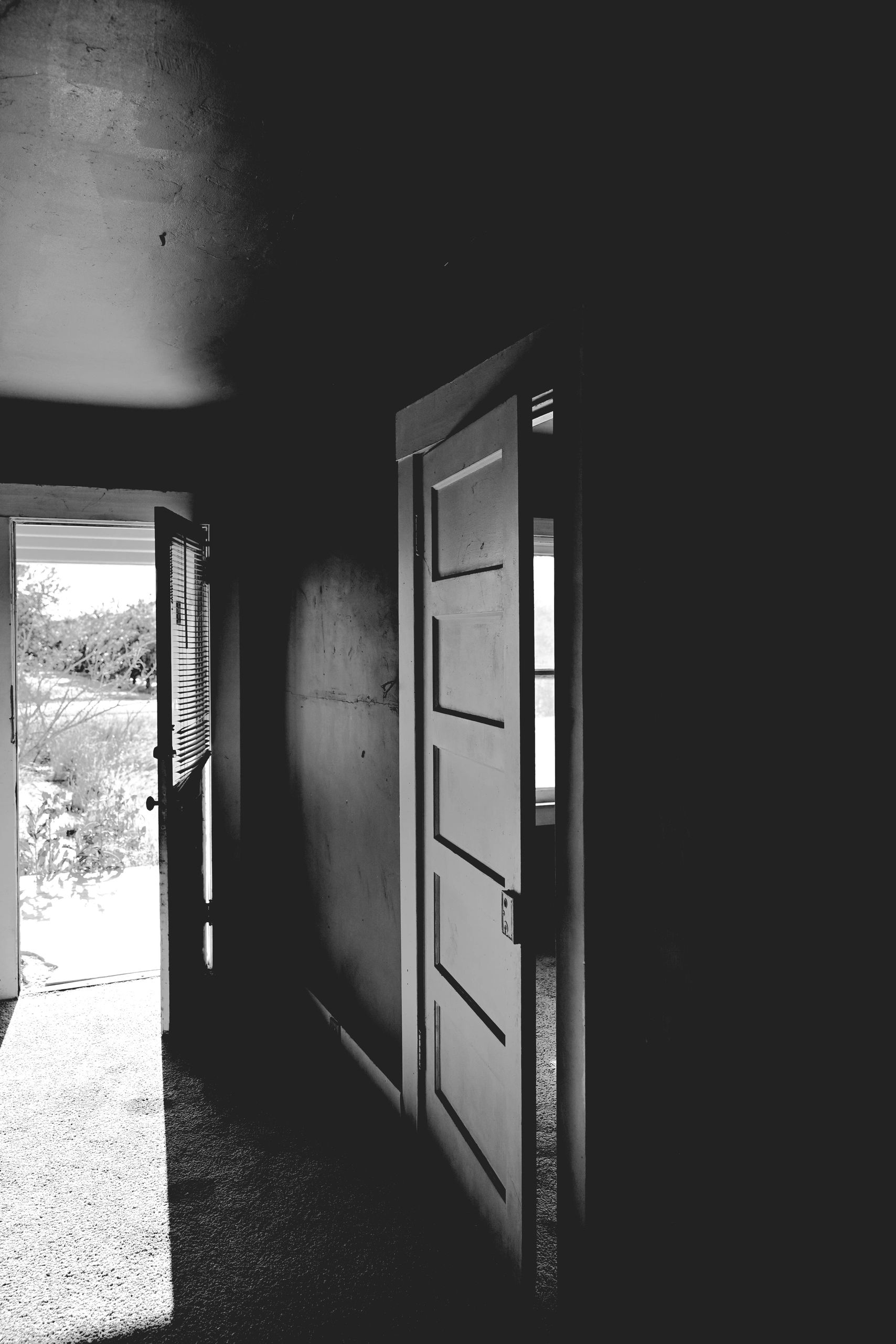 Open doors with sunlight streaming into a dark room.