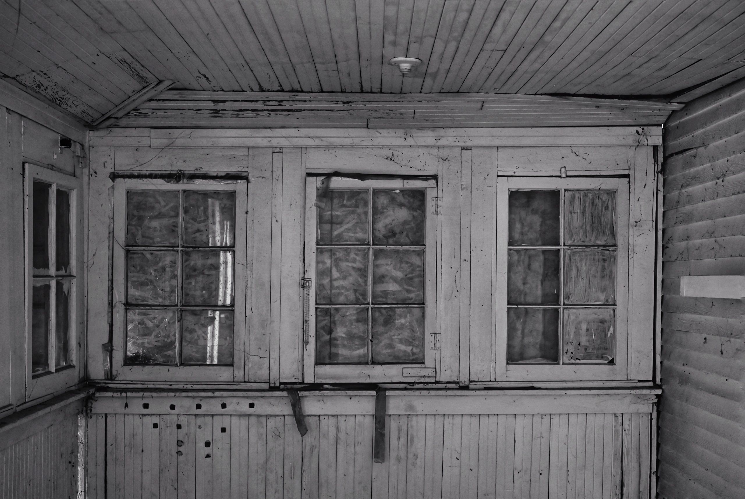 Aged wooden windows and walls in a monochrome setting.